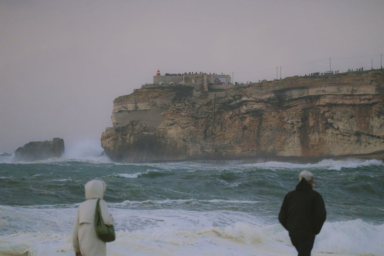 People Walking on the Coast of the Atlantic with the Fort of Sao Miguel Arcanjo in the Background, Nazare, Portugal